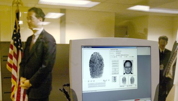 A U.S. embassy official walks past a monitor displaying biometric data during a demonstration of a new procedure, fingerprint scans, to the media at the U.S. Embassy in Moscow - Sputnik International