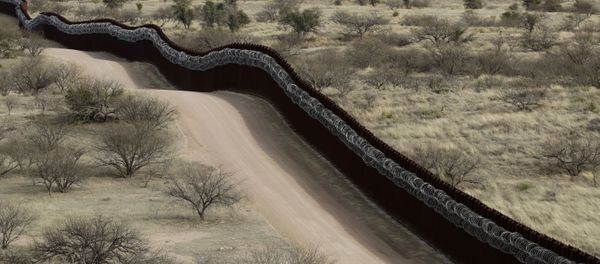 In this March 2, 2019 file photo, a razor-wire-covered border wall separates the United States, at left, from Mexico east of Nogales, Ariz In this March 2, 2019 file photo, a razor-wire-covered border wall separates the United States, at left, from Mexico east of Nogales, Ariz - Sputnik International