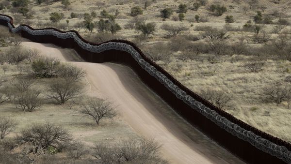  In this March 2, 2019 file photo, a razor-wire-covered border wall separates the United States, at left, from Mexico east of Nogales, Ariz - Sputnik International