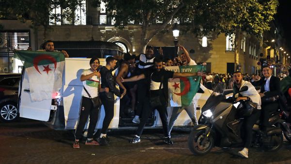 Algeria's supporters celebrate with the Algerian national flag in the Champs Elysee Avenue in Paris, after Algeria won 1-0 the 2019 Africa Cup of Nations (CAN) final football match between Algeria and Senegal, on July 19, 2019 Algeria's supporters celebrate with the Algerian national flag in the Champs Elysee Avenue in Paris, after Algeria won 1-0 the 2019 Africa Cup of Nations (CAN) final football match between Algeria and Senegal, on July 19, 2019 - Sputnik International