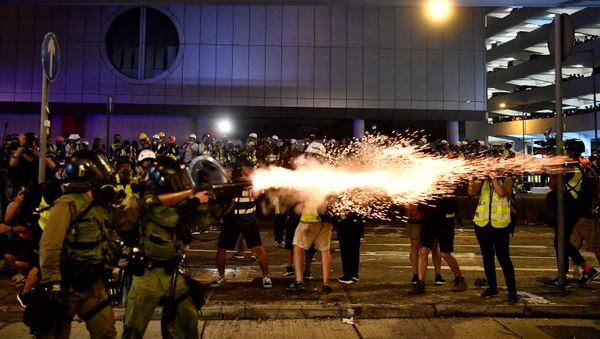 A policeman fires tear gas at protesters to disperse them after a march against a controversial extradition bill in Hong Kong on July 21, 2019.  - Sputnik International