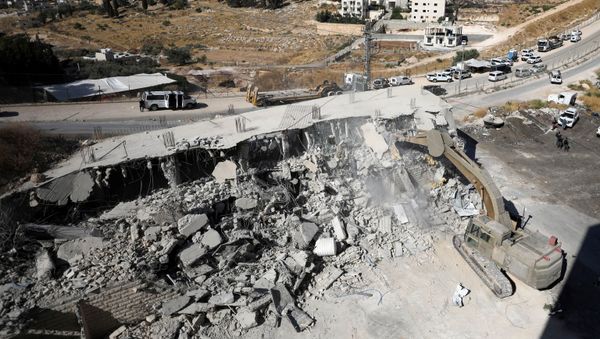 An Israeli military bulldozer demolishes a building near a military barrier in Sur Baher, a Palestinian village on the edge of East Jerusalem in an area that Israel captured and occupied in the 1967 Middle East War July 22, 2019 - Sputnik International