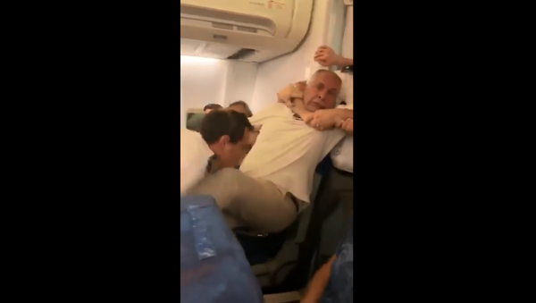 Security personnel forcibly remove passenger from a Tarom Airlines flight to Cairo, Egypt. - Sputnik International