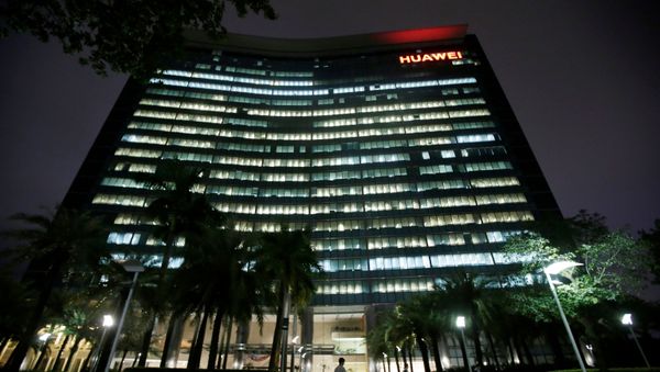 Employees walk past a research and development building with lights on at Huawei headquarters in Shenzhen - Sputnik International