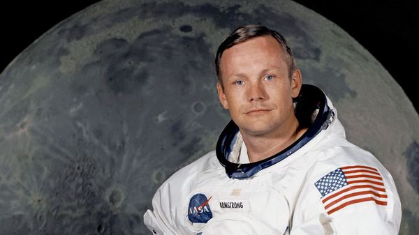Portrait of Astronaut Neil A. Armstrong, commander of the Apollo 11 Lunar Landing mission in his space suit, with his helmet on the table in front of him. Behind him is a large photograph of the lunar surface. - Sputnik International