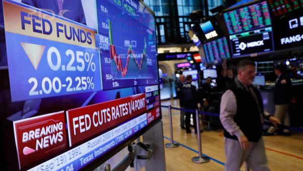 A screen displays the U.S. Federal Reserve interest rates announcement as traders work on the floor of the New York Stock Exchange (NYSE) in New York, U.S., July 31, 2019. - Sputnik International