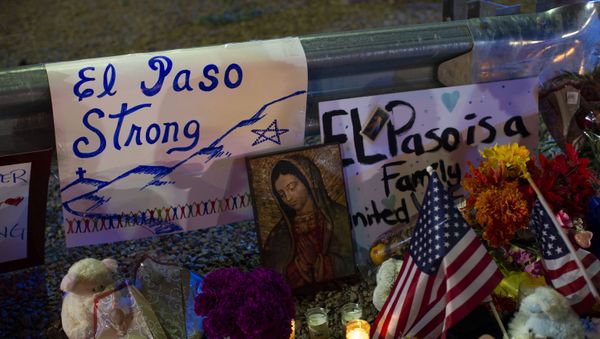 A Virgin Mary painting, flags and flowers adorn a makeshift memorial for the victims of Saturday's mass shooting at a shopping complex in El Paso, Texas, Sunday, Aug. 4, 2019 - Sputnik International