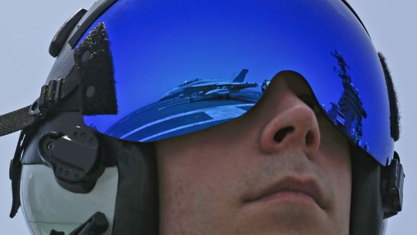 In this Thursday, May 30, 2019, photo released by the U.S. Navy, Lt. Rob Morris, from Annapolis, Md., observes an F/A-18F Super Hornet from the Jolly Rogers of Strike Fighter Squadron (VFA) 103 land on the flight deck of the Nimitz-class aircraft carrier USS Abraham Lincoln (CVN 72) in Arabian Sea - Sputnik International