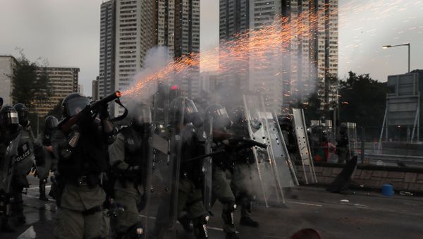 A riot police fires tear gas during a confrontation with protesters on Monday, Aug. 5, 2019. Droves of protesters filled public parks and squares in several Hong Kong districts on Monday in a general strike staged on a weekday to draw more attention to their demands that the semi-autonomous Chinese city's leader resign. - Sputnik International