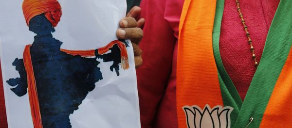 A participant displays an artist's impression of the India map decorated with a saffron shawl as ruling Bharatiya Janata Party (BJP) supporters celebrate government revoking disputed Kashmir's special status in Prayagraj, India, Monday, Aug. 5, 2019. - Sputnik International