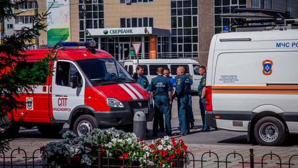 Russian Emergency Situation Ministry officers wait near their cars in the town of Achinsk, some 150 km west of Krasnoyarsk, Russia. The fire hit ammunition depot at a military base outside the town on August 5 leaving leaving 12 people injured - Sputnik International