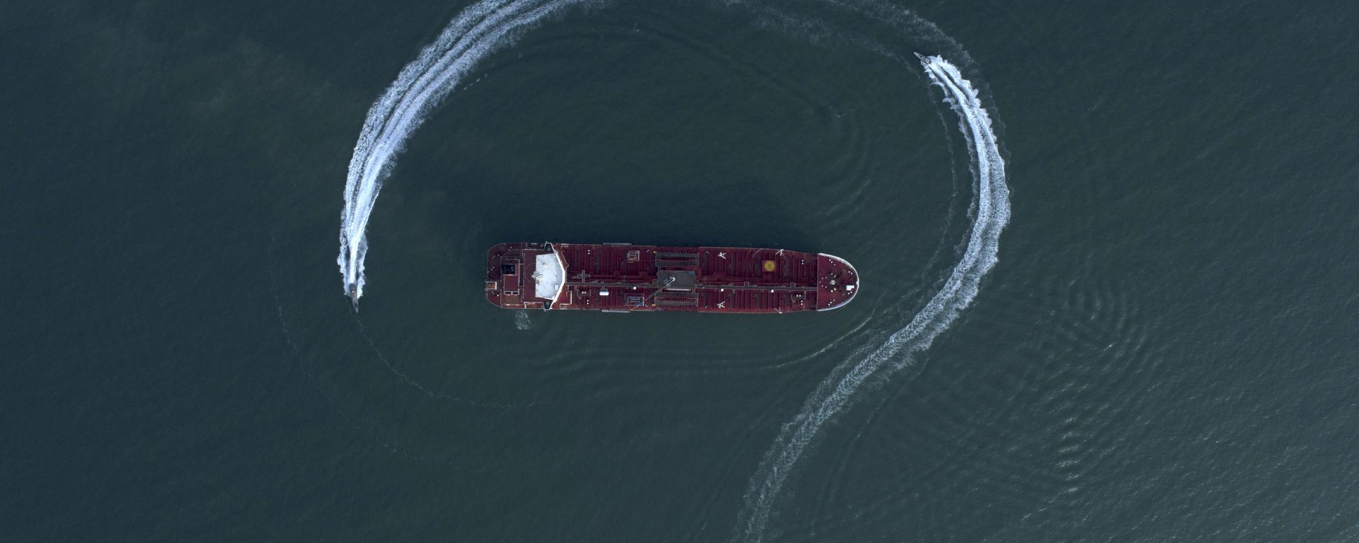 In this Sunday, July 21, 2019 photo, an aerial view shows a speedboat of Iran's Revolutionary Guard moving around the British-flagged oil tanker Stena Impero which was seized in the Strait of Hormuz on Friday by the Guard, in the Iranian port of Bandar Abbas - Sputnik International, 1920, 13.07.2026