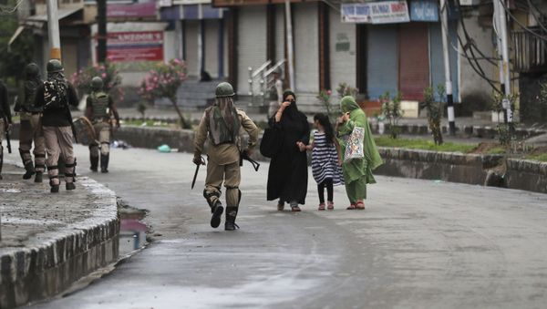 Kashmiris walks past Indian paramilitary soldiers patrolling a street in Srinagar, Indian controlled Kashmir, Saturday, Aug. 10, 2019 - Sputnik International