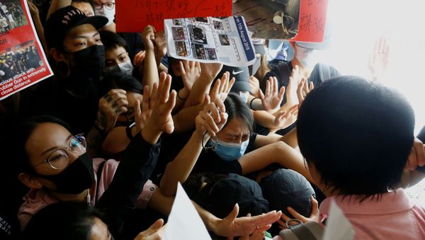 Anti-government protesters try to prevent a passenger from breaching a barricade in front of departure gates, during a demonstration at Hong Kong Airport, China August 13, 2019. - Sputnik International