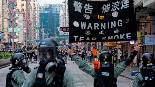 A riot police raises a warning flag as they try to disperse anti-extradition bill protesters by tear gas at Sham Shui Po in Hong Kong, China August 11, 2019. REUTERS/Tyrone Siu - Sputnik International