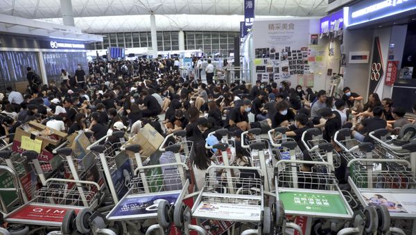 Protesters use luggage trolleys to block the walkway to the departure gates during a demonstration at the Airport in Hong Kong Protesters use luggage trolleys to block the walkway to the departure gates during a demonstration at the Airport in Hong Kong - Sputnik International