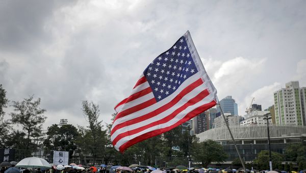 A U.S. flag flutters as people gather at Victoria Park to take part in an anti-extradition bill protest in Hong Kong, Sunday, Aug. 11, 2019. Protesters have begun gathering at the park in central Hong Kong for another day of demonstrations that have generally started peacefully but often ended in violent clashes with police. - Sputnik International