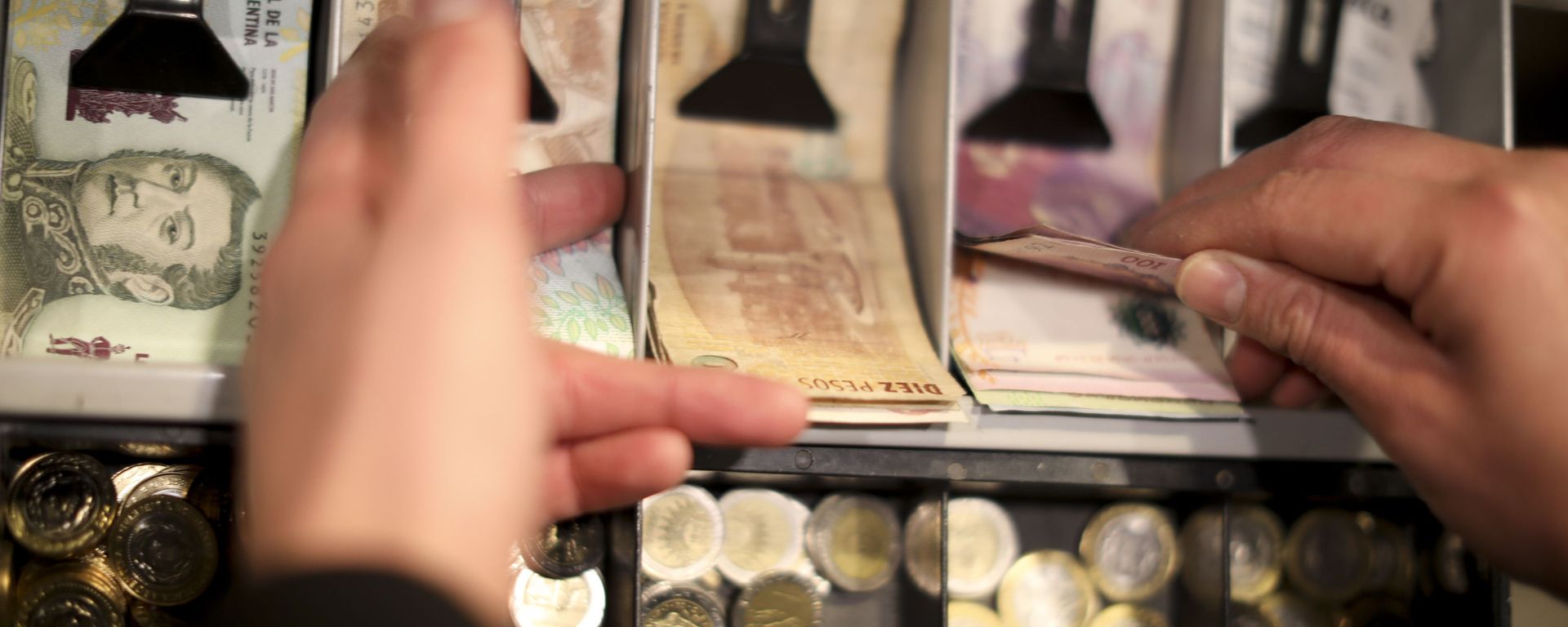 A man holds a 100 peso bill in the cashier of a restaurant in Buenos Aires, Argentina, Wednesday, Aug. 14, 2019. President Mauricio Macri announced economic relief for poor and working-class Argentines that include an increased minimum wage, reduced payroll taxes, a bonus for informal workers and a freeze in gasoline prices. The conservative leader said Wednesday he's acting in recognition of the anger Argentines expressed in Sunday's primary election, when Macri trailed his populist rival by 15 percentage points. A man holds a 100 peso bill in the cashier of a restaurant in Buenos Aires, Argentina, Wednesday, Aug. 14, 2019. President Mauricio Macri announced economic relief for poor and working-class Argentines that include an increased minimum wage, reduced payroll taxes, a bonus for informal workers and a freeze in gasoline prices. The conservative leader said Wednesday he's acting in recognition of the anger Argentines expressed in Sunday's primary election, when Macri trailed his populist rival by 15 percentage points. - Sputnik International, 1920, 20.11.2023