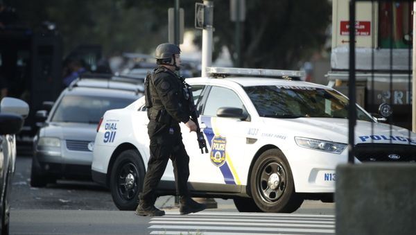 A police officer patrols the block near a house as they investigate an active shooting situation, Wednesday, Aug. 14, 2019, in the Nicetown neighborhood of Philadelphia. - Sputnik International