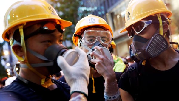 Protesters protect themselves with helmets and masks during a demonstration in Hong Kong - Sputnik International