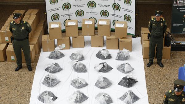 Police officers stand guard over what they say are seized packages of cocaine disguised as printer toner during a media presentation in Bogota, Colombia, 7 September 2015 - Sputnik International