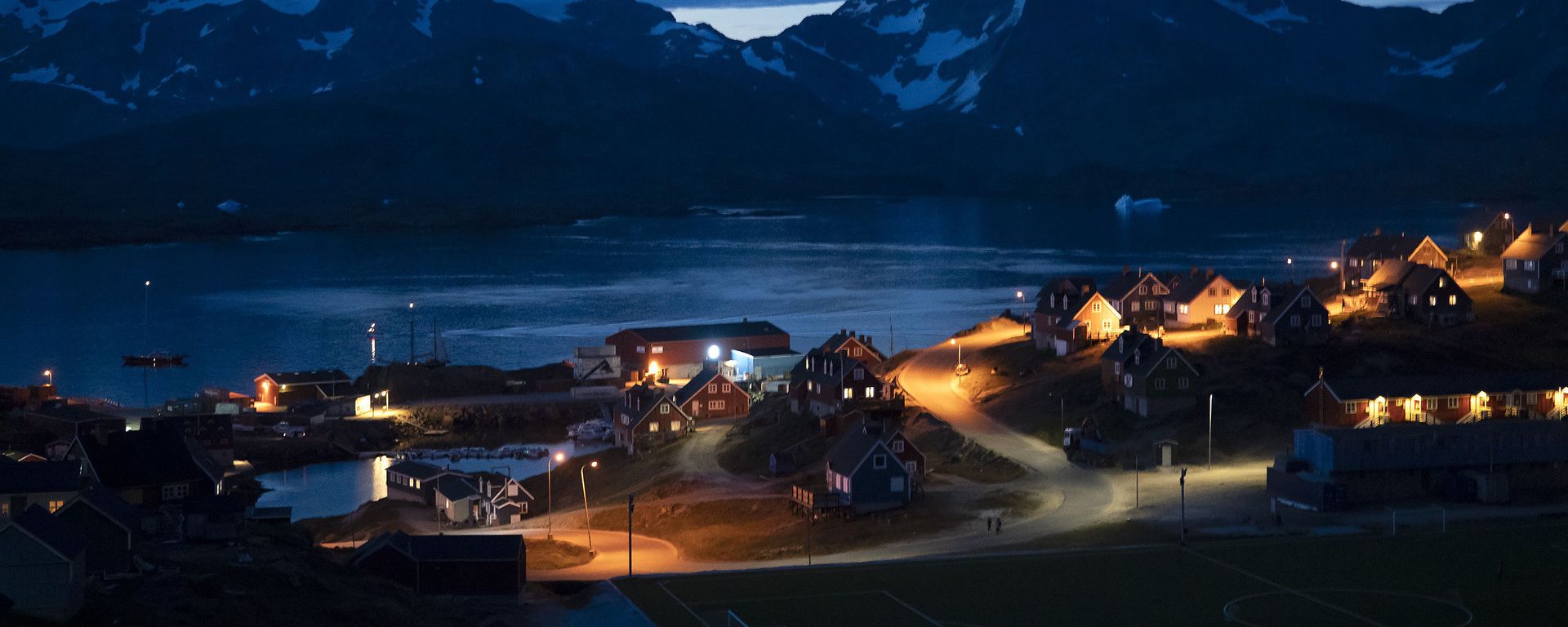 In this photo taken late Friday, Aug. 16, 2019, homes are illuminated after the sunset in Tasiilaq, Greenland.  - Sputnik International, 1920, 05.04.2025