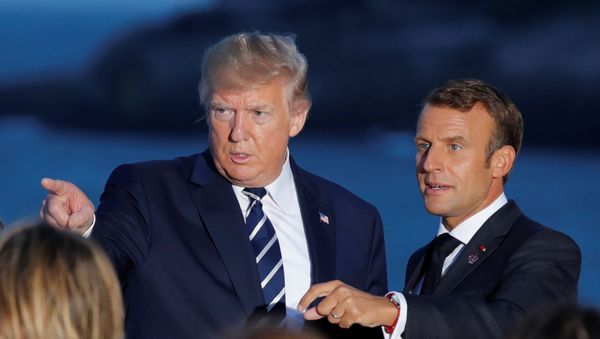 French President Emmanuel Macron talks with U.S. President Donald Trump after posing for a family photo with invited guests during the G7 summit in Biarritz, France, August 25, 2019. - Sputnik International