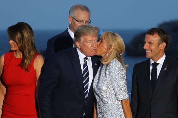 French President's wife Brigitte Macron kisses US President Donald Trump, flanked by US First Lady Melania Trump and France's President Emmanuel Macron, prior to a family picture with G7 leaders and guests, on the second day of the annual G7 summit in Biarritz, south-west France on August 25, 2019.  - Sputnik International