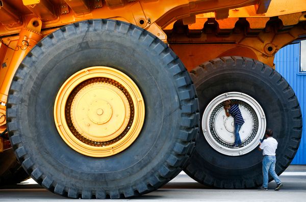 People take a selfie at the wheels of BelAZ dump trucks at the Belarusian Autoworks manufacturer in Zhodino, Belarus August 27, 2019.   - Sputnik International
