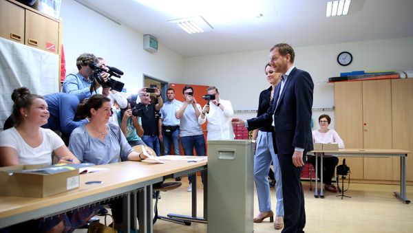 Michael Kretschmer, Saxony's State Premier and top candidate of his conservative CDU party, casts his ballot for state elections in Saxony on September 1, 2019 in Dresden, eastern Germany; at his side is his partner Annett Hofmann. - Sputnik International