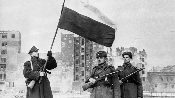 Soviet troops pose as Polish soldier raises Polish flag over Warsaw in January 1945. The liberation of Poland cost the Red Army 600,000 casualties. - Sputnik International