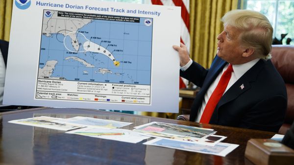 President Donald Trump holds a chart as he talks with reporters after receiving a briefing on Hurricane Dorian in the Oval Office of the White House - Sputnik International