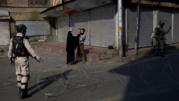 FILE - In this 23 August 2019 file photo, a Kashmiri family waits for a lift to take their sick child to hospital as Indian paramilitary soldiers stand guard near a checkpoint during the lock-down in Srinagar, in Indian-controlled Kashmir. - Sputnik International