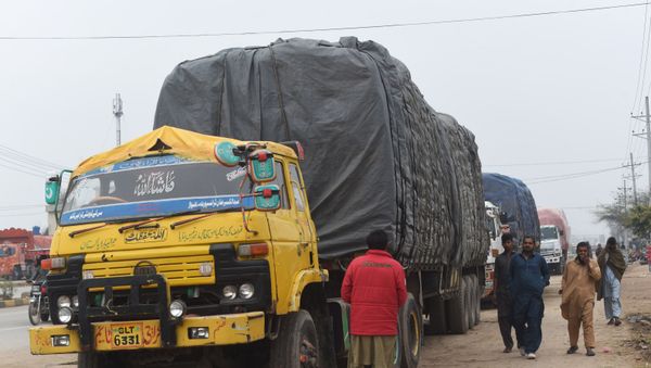 Pakistani drivers walk next to loaded trucks parked along a road near the Wagah border between Pakistan and India on 20 February 2019, following the withdrawal of trade privileges for Pakistan by the Indian government. - Sputnik International