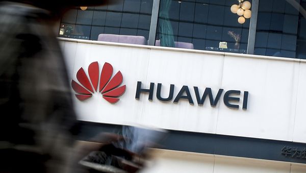 In this July 30, 2019, file photo a woman walks by a Huawei retail store in Beijing. - Sputnik International