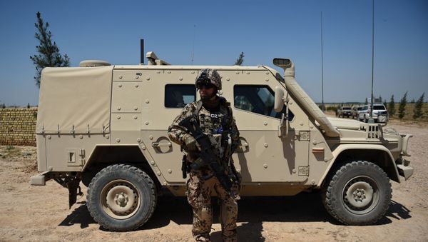 A German soldier from the NATO coalition stands guard during a visit by resolute support spokesman Brigadier General H. Cleveland outside the Shaheen 209th military corps training center in Mazar-i-Sharif on April 26, 2016.  - Sputnik International