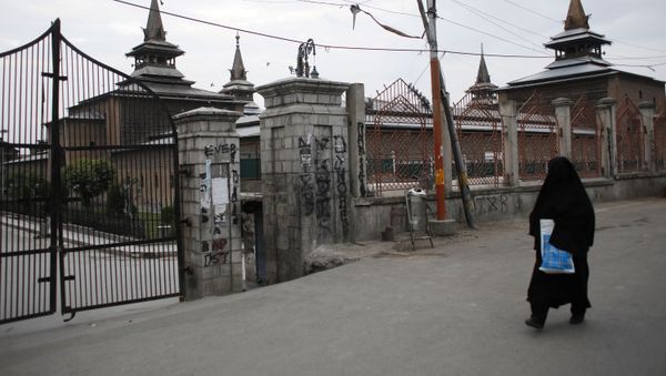 A Kashmiri woman walks past the locked Jamia Masjid (grand mosque) during restrictions, after scrapping of the special constitutional status for Kashmir by the Indian government, in Srinagar, August 26, 2019 - Sputnik International