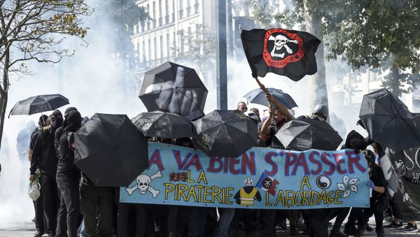 Protestors protect themselves with umbrellas during clashes with police on the sideline of an anti-government demonstration called by the Yellow Vests (Gilets Jaunes) movement in Nantes, Western France on September 14, 2019. - Sputnik International