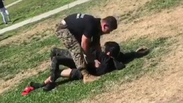 A Marine recruiter blindside tackling a student so hard to break up the fight that if appears he hurts the student and does more damage than the actual fight itself - Sputnik International