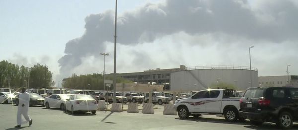 In this image made from a video broadcast on the Saudi-owned Al-Arabiya satellite news channel on Saturday, Sept. 14, 2019, a man walks through a parking lot as the smoke from a fire at the Abqaiq oil processing facility can be seen behind him in Buqyaq, Saudi Arabia. Drones launched by Yemen's Houthi rebels attacked the world's largest oil processing facility in Saudi Arabia and another major oilfield Saturday, sparking huge fires at a vulnerable chokepoint for global energy supplies In this image made from a video broadcast on the Saudi-owned Al-Arabiya satellite news channel on Saturday, Sept. 14, 2019, a man walks through a parking lot as the smoke from a fire at the Abqaiq oil processing facility can be seen behind him in Buqyaq, Saudi Arabia. Drones launched by Yemen's Houthi rebels attacked the world's largest oil processing facility in Saudi Arabia and another major oilfield Saturday, sparking huge fires at a vulnerable chokepoint for global energy supplies - Sputnik International