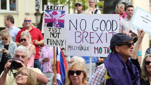 People hold placards as they protest outside a restaurant where British Prime Minister Boris Johnson met with European Commission President Jean-Claude Juncker in Luxembourg, September 16, 2019. - Sputnik International