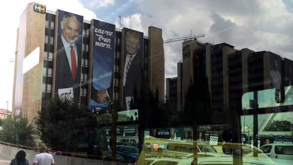 A reflection in a bus window shows a Likud party election campaign banner depicting Israeli Prime Minister Benjamin Netanyahu shaking hands with U.S. President Donald Trump in Jerusalem 15 September 2019. - Sputnik International