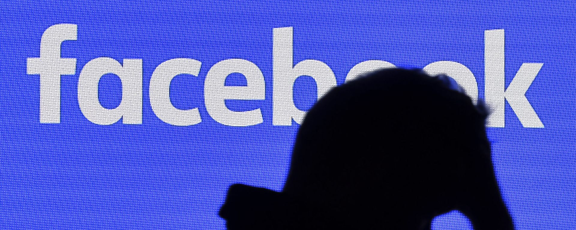 A man passes a facebook screen A man passes a facebook screen - Sputnik International, 1920, 06.10.2021