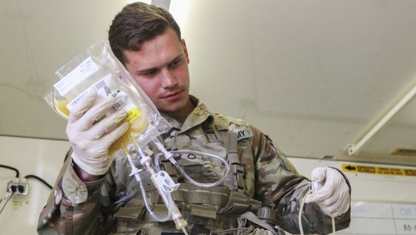 Pfc. Jaritt Louthan, a medical lab technician with 432nd Blood Support Detachment, 28th Combat Support Hospital, 44th Medical Brigade, and a native of Cleveland, re-hydrates freeze dried plasma during an airdrop test Sept. 19, 2019 at Fort Bragg, N.C. Jaritt is among the first few Soldiers to test the durability of the plasma packaging by parachuting to collect data for possible future use on the battlefield - Sputnik International