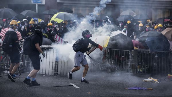 Protesters react among tear gas fired by police in the Sha Tin district of Hong Kong on October 1, 2019, as the city observes the National Day holiday to mark the 70th anniversary of communist China's founding - Sputnik International
