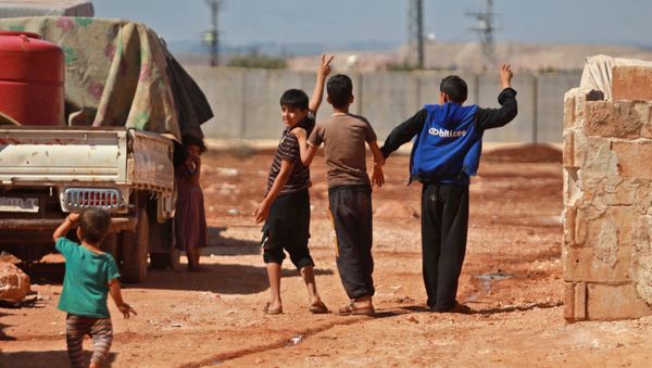 Children gesture towards the barbed-wire-topped concrete fence demarcating the border between Syria and Turkey, at a camp for displaced Syrians in Atme in the northwestern Idlib province, near the borther with Turkey, on September 23, 2019.  - Sputnik International