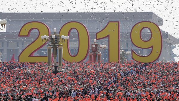 Doves are released over people holding Chinese flags at the end of the parade marking the 70th founding anniversary of People's Republic of China, on its National Day in Beijing, China October 1, 2019 - Sputnik International