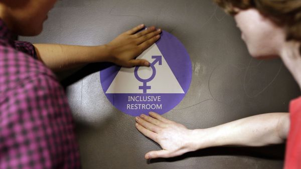 Destin Cramer, left, and Noah Rice place a new sticker on the door at the ceremonial opening of a gender neutral bathroom at Nathan Hale high school Tuesday, May 17, 2016, in Seattle - Sputnik International