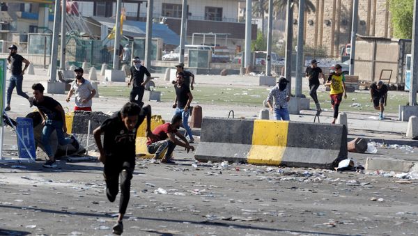 Demonstrators run at a protest during a curfew, three days after the nationwide anti-government protests turned violent, in Baghdad, Iraq October 4, 2019 - Sputnik International