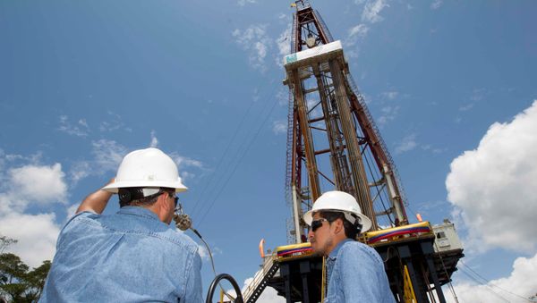 Workers stand near an oil drilling rig belonging to Petroamazonas at Miranda Port in Tiputini, Ecuador - Sputnik International